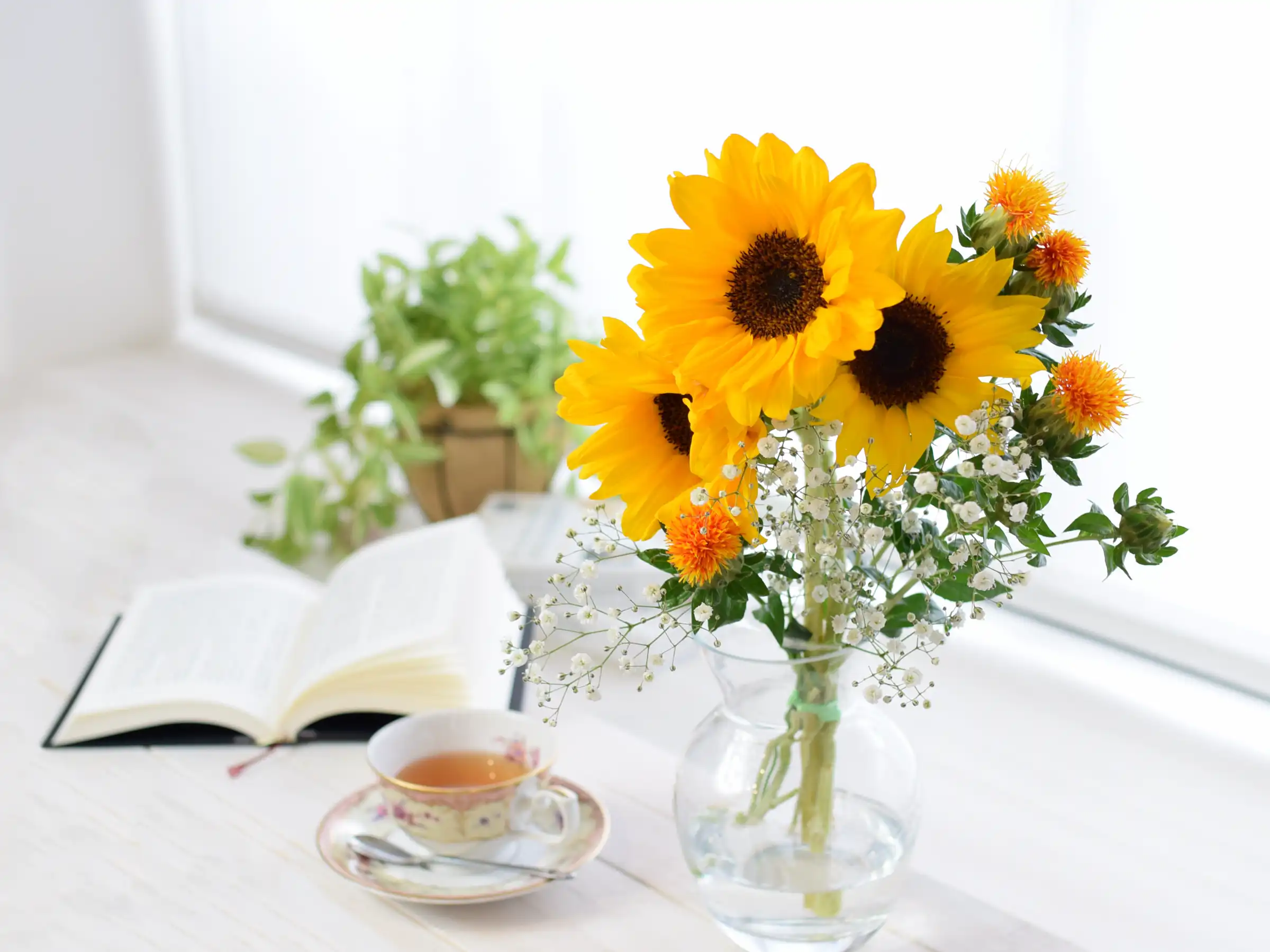 花瓶にいけたひまわりの花束とティーカップ